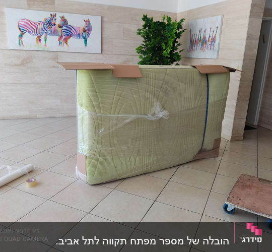ארגז עטוף בניילון עם עגלת גלגלים וסרט דבק